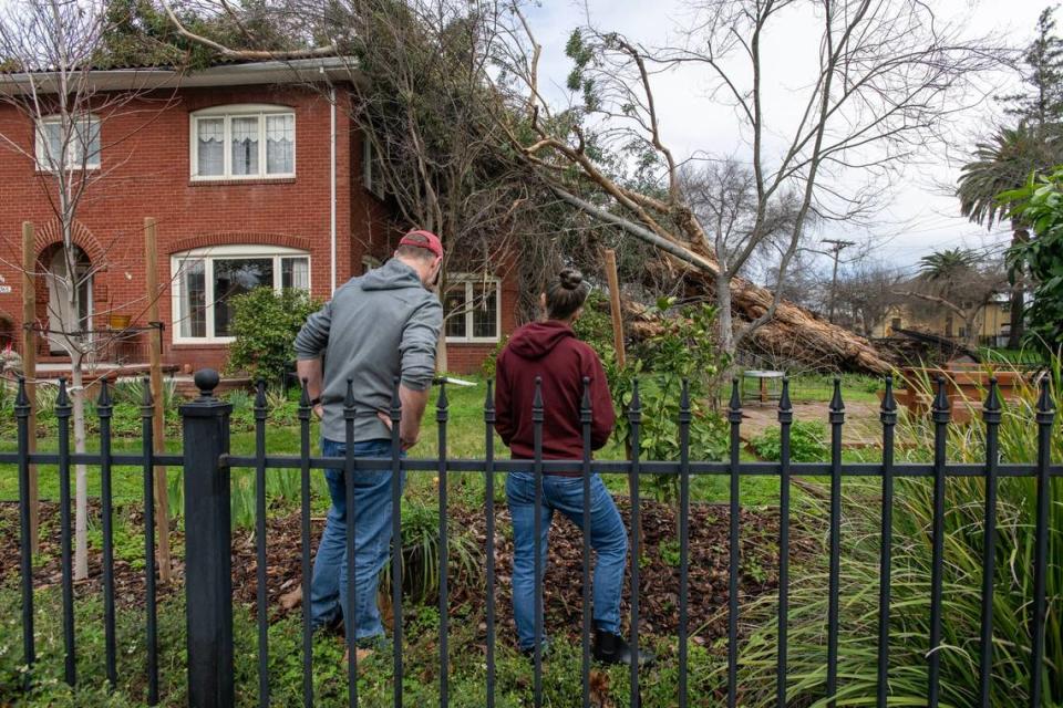 Home owners Broc and Arlene Krause survey the damage to their home on Donner Way in Sacramento’s Curtis Park neighborhood on Monday, the day after a tree fell during a windstorm that caused tree damage throughout the region.