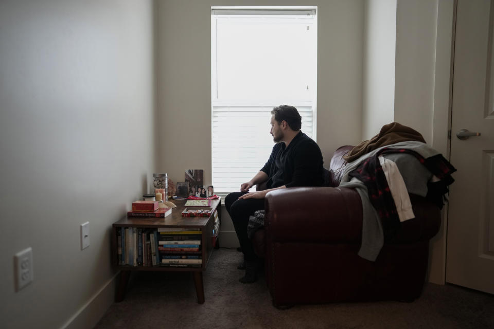 Ashton Colby looks out the window from his meditation corner in his apartment in Columbus, Ohio, on Thursday, Jan. 18, 2024. Ohio Gov. Mike DeWine announced proposals this month that transgender advocates say could block access to gender-affirming care provided by independent clinics and general practitioners, leaving thousands of adults scrambling for treatment and facing health risks. Colby, 31, fears the clinic where he gets the testosterone he has taken since age 19 would no longer offer it. (AP Photo/Carolyn Kaster)