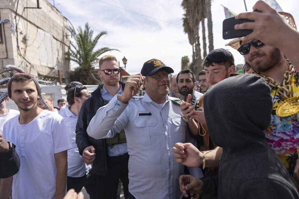 Israeli Minister of National Security Itamar Ben-Gvir, center, dressed in a costume combining elements of various uniforms of forces under his command, celebrate the Jewish holiday of Purim, in the West Bank city of Hebron, Tuesday, March 7, 2023. Ben-Gvir danced, sang, and took selfies with partygoers and soldiers at an event in an Israeli settlement in Hebron. Ben-Gvir, an ultranationalist politician in Benjamin Netanyahu's new government, lives in an adjacent settlement. The Jewish holiday of Purim commemorates the Jews salvation from genocide in ancient Persia, as recounted in the Book of Esther. (AP Photo/Ohad Zwigenberg)