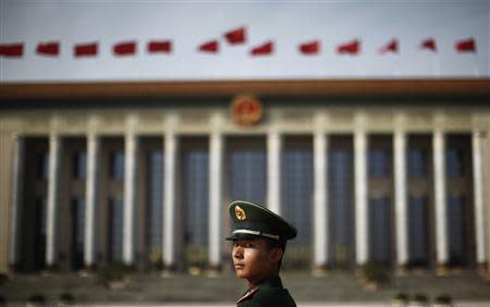 A paramilitary police officer stands in front of the Great Hall of the People at Beijing's Tiananmen Square, in this file picture taken November 7, 2012. REUTERS/Carlos Barria