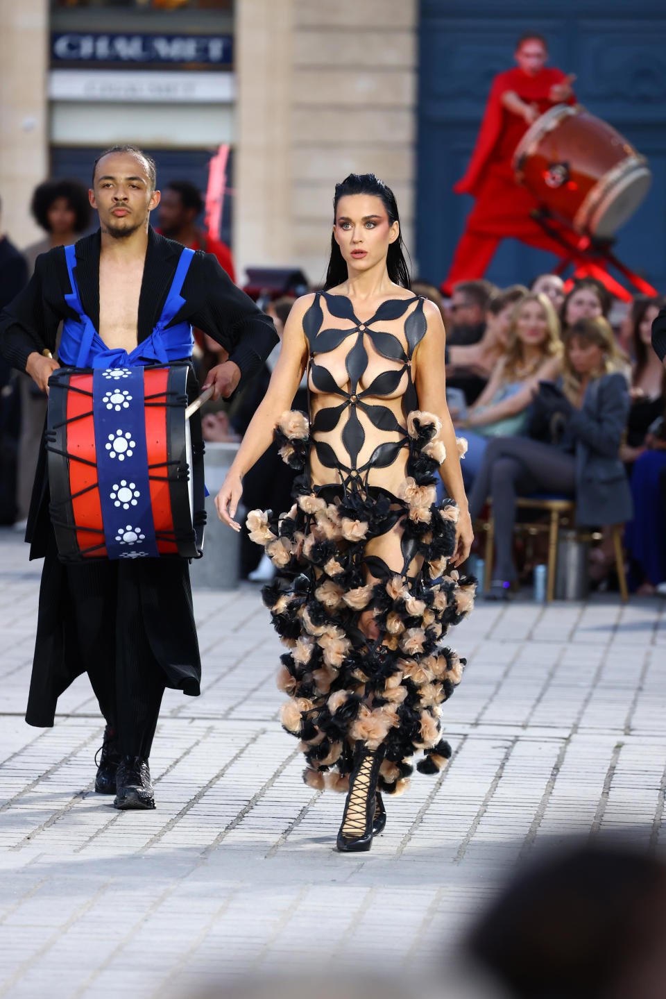 Katy Perry walks the runway during Vogue World: Paris at Place in Paris, France wearing black strappy shoes and Noir Kei Ninomiya Gown