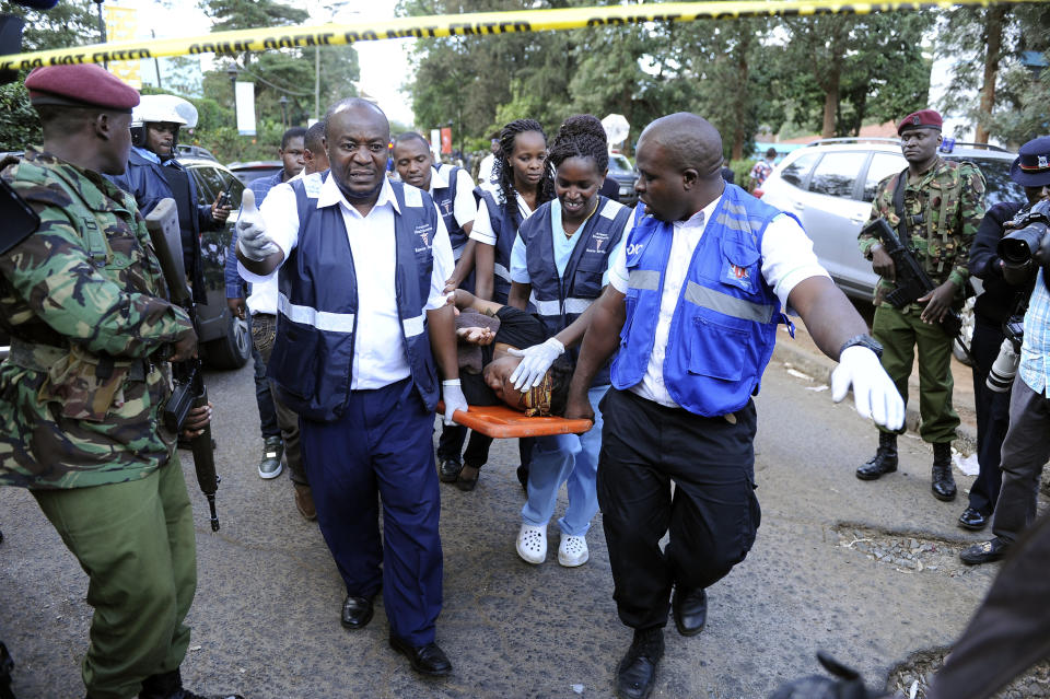 Medics rescue a civilian from the scene at a hotel complex in Nairobi, Kenya Tuesday, Jan. 15, 2019.Terrorists attacked an upscale hotel complex in Kenya's capital Tuesday, sending people fleeing in panic as explosions and heavy gunfire reverberated through the neighborhood. (AP Photo/John Muchucha))