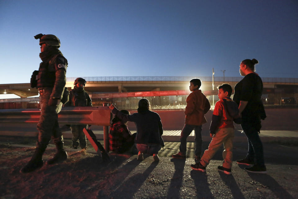 Military police wearing the insignia of the new National Guard detain migrants from Guatemala to keep them from crossing the Rio Grande from Ciudad Juarez, Mexico to El Paso, Texas, late Monday, June 24, 2019. (AP Photo/Christian Chavez)