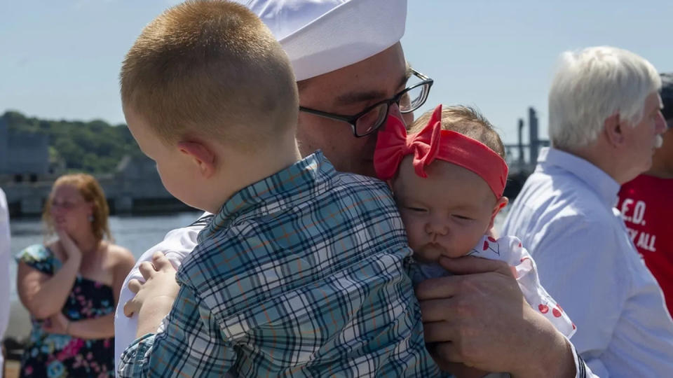 A sailor holds his newborn for the first time after returning home from a deployment in 2021. (Navy)