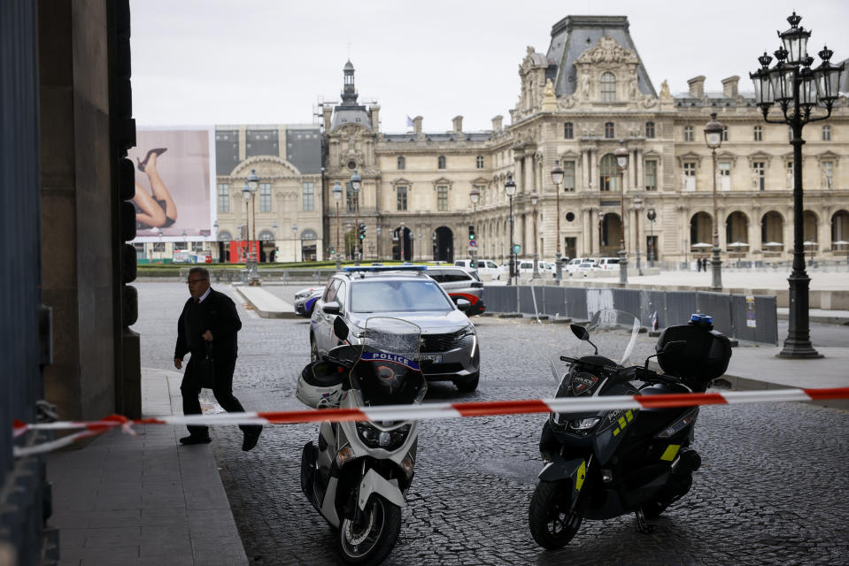 Vehículos de la policía mientras agentes vigilan afuera del Museo del Louvre durante una evacuación luego de que recibieron una amenaza de bomba escrita, en París, el sábado 14 de octubre de 2023. (AP Foto/Thomas Padilla)