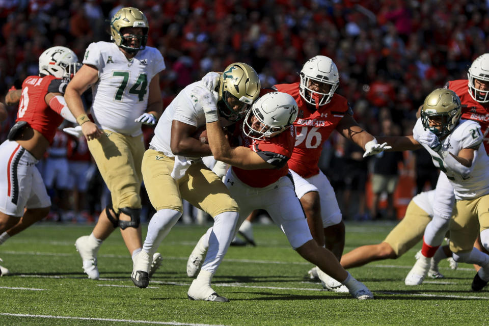 South Florida quarterback Gerry Bohanon, left, is tackled by Cincinnati linebacker Wilson Huber during the first half of an NCAA college football game, Saturday, Oct. 8, 2022, in Cincinnati. (AP Photo/Aaron Doster)