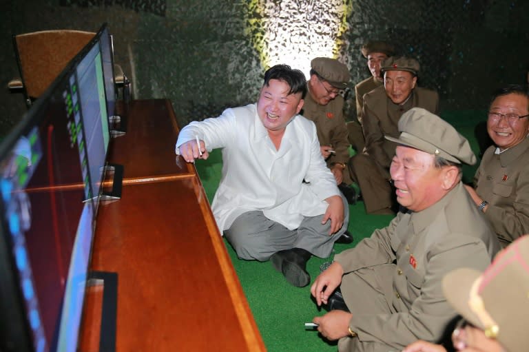 A North Korean official media photo from August 25, 2016 shows North Korean leader Kim Jong-Un (C) watching the test-firing of a strategic submarine-launched ballistic missile at an undisclosed location