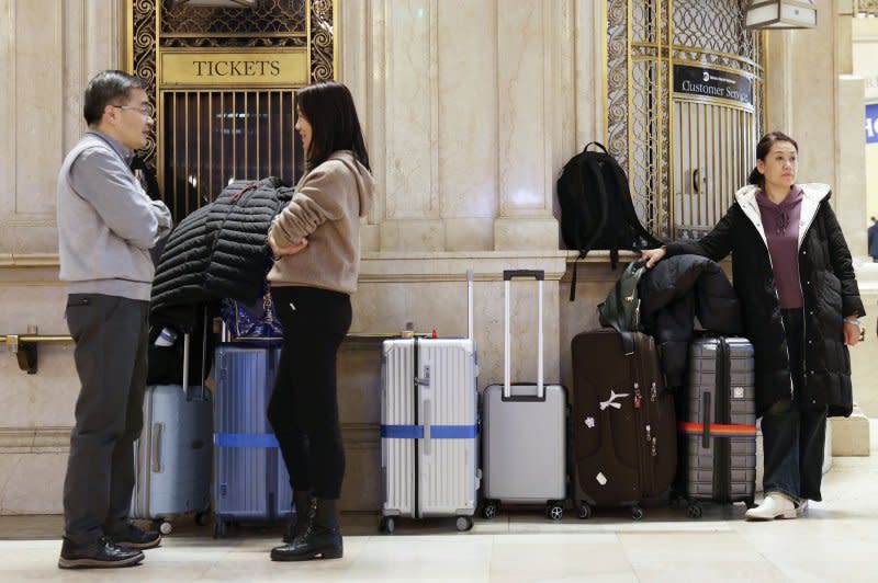 Commuters and travelers stand at a ticket window with carry on luggage at Grand Central Terminal in New York City on Thursday. Photo by John Angelillo/UPI