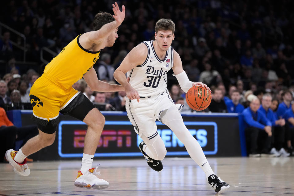 Duke's Kyle Filipowski (30) drives against Iowa's Filip Rebraca during the first half of an NCAA college basketball game in the Jimmy V Classic, Tuesday, Dec. 6, 2022, in New York. (AP Photo/John Minchillo)