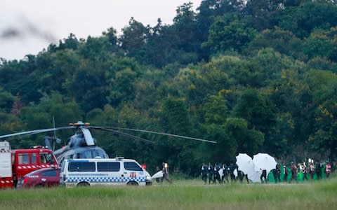 An emergency team rushing to a helicopter as they carry one of the rescued boys  - Credit: Vincent Thian /AP