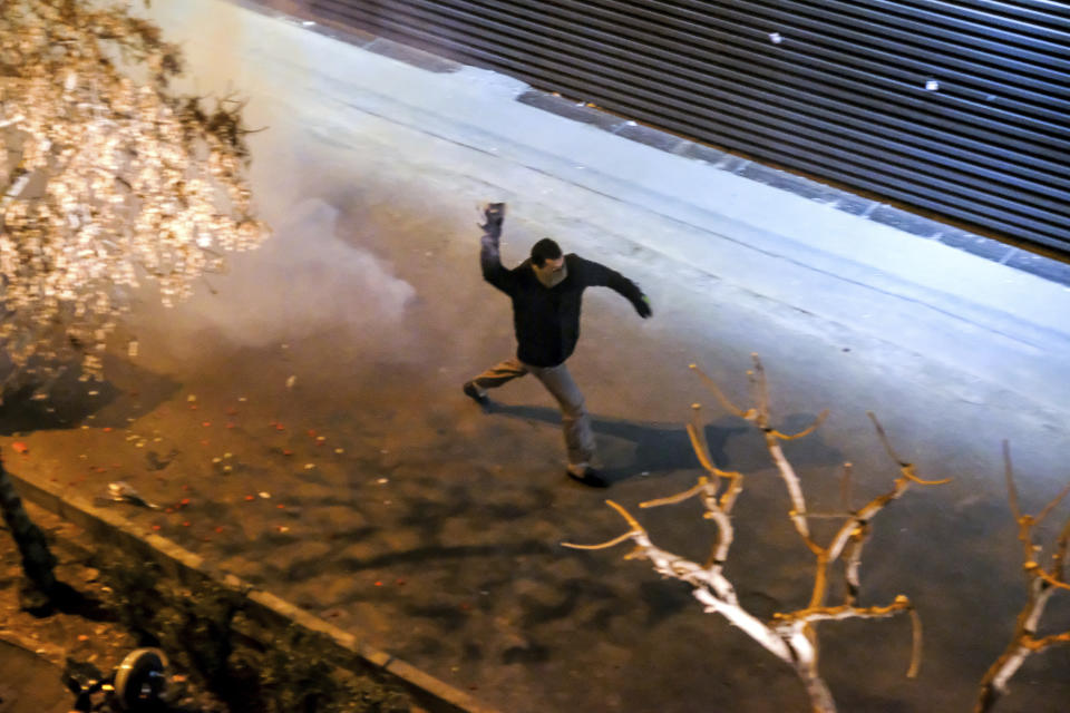 In this photograph taken Saturday, Jan. 11, 2020, an Iranian protester prepares to throw a tear gas canister back at police in front of Amir Kabir University in Tehran, Iran, during a demonstration to remember victims of a Ukrainian airplane shot down by an Iranian missile. On Monday, Jan. 13, 2020, online videos purported to show that Iranian security forces fired both live ammunition and tear gas to disperse demonstrators protesting against the Islamic Republic's initial denial that it shot down a Ukrainian jetliner. (AP Photo)