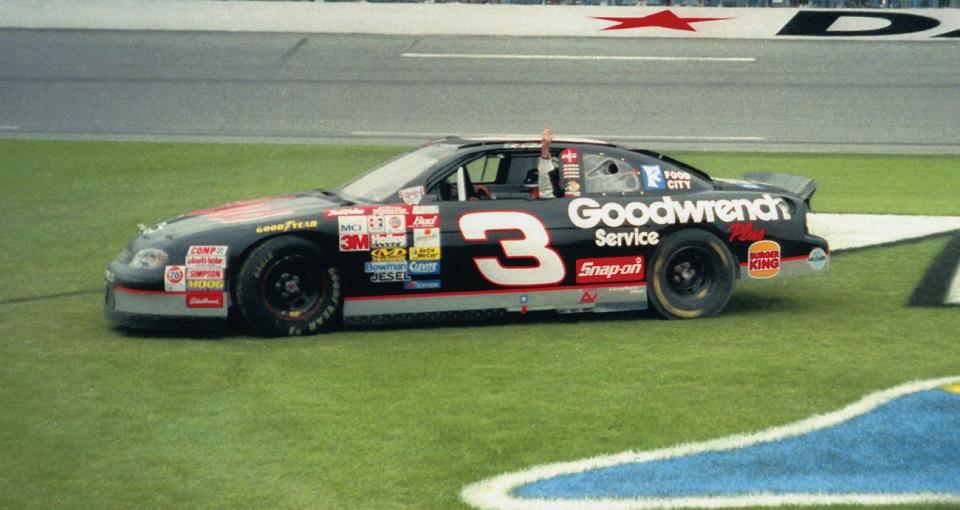 Dale Earnhardt raises his finger out of his window while in the infield