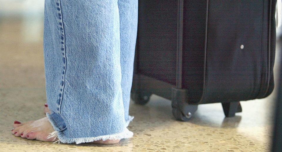 Removing shoes became one of many added security measures. <a href="https://www.gettyimages.com/detail/news-photo/the-feet-of-a-barefoot-traveler-are-seen-with-her-luggage-news-photo/2203634?adppopup=true" rel="nofollow noopener" target="_blank" data-ylk="slk:Tim Boyle/Getty Images;elm:context_link;itc:0;sec:content-canvas" class="link ">Tim Boyle/Getty Images</a>