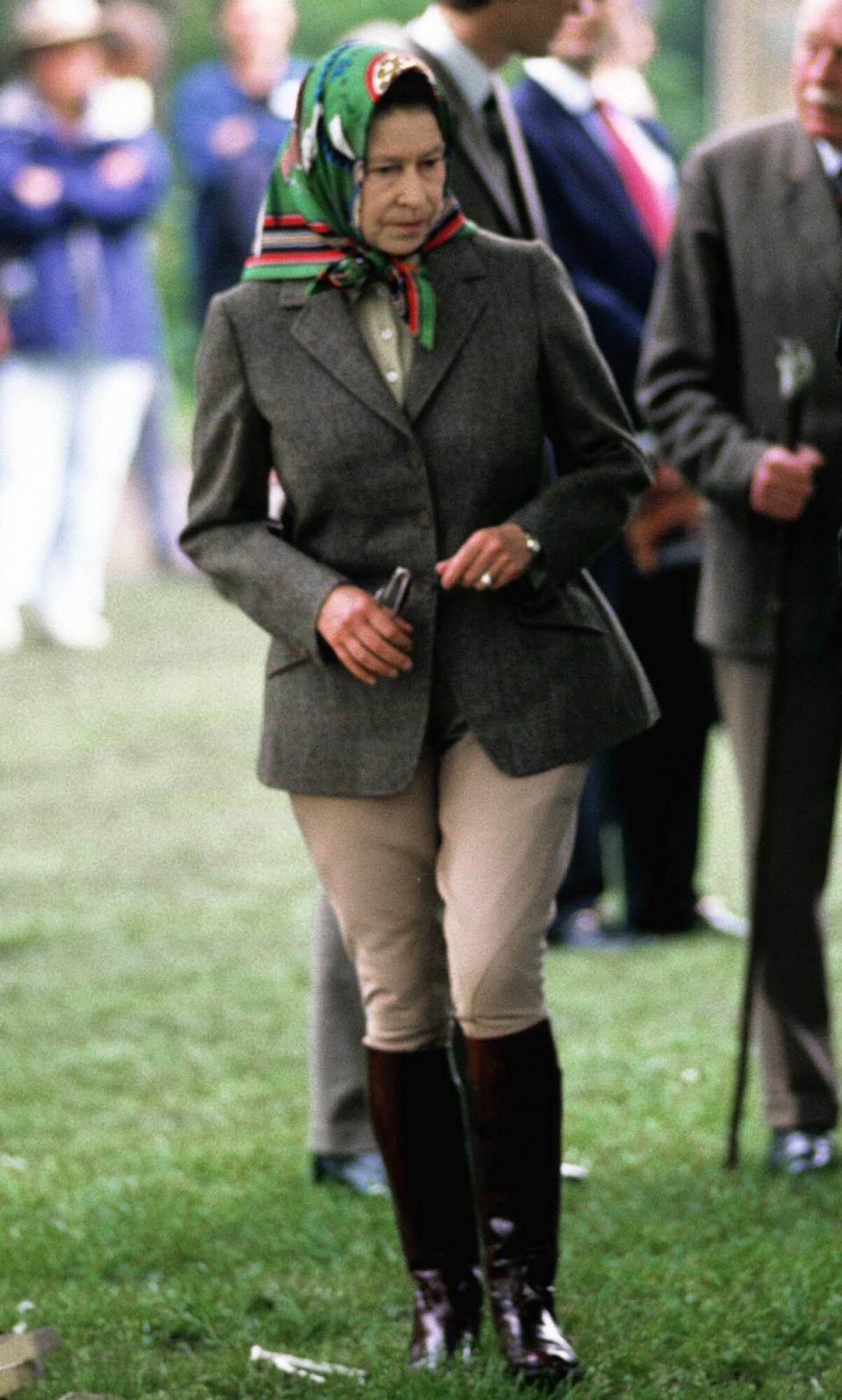 Queen Elizabeth ll walks in riding gear as she visits the Royal Windsor Horse Show in May 1988 in Windsor, England