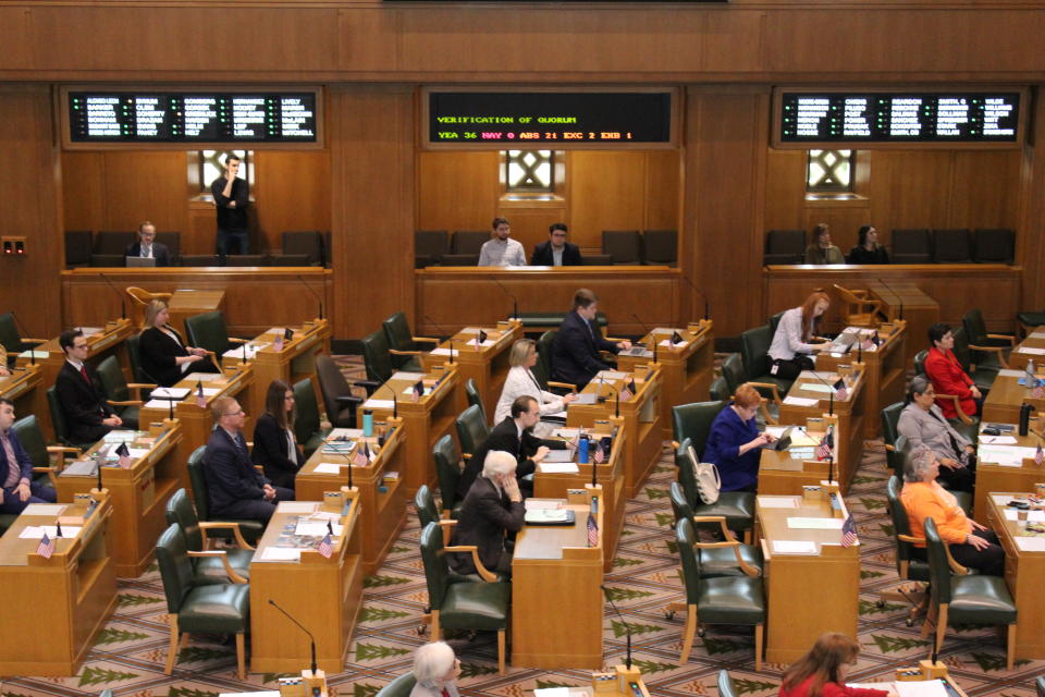 Members of the Oregon House of Representatives sit at their desks in Salem, Ore., during a roll call, Monday, March 2, 2020, for a roll call. A walkout by most Republican members entered its second week, and again prevented the House from convening. (AP Photo/Andrew Selsky)