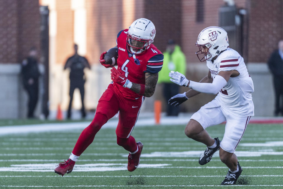 Liberty's CJ Daniels runs the ball against UMass' Isaiah Rutherford during second half of an NCAA college football game, Saturday, Nov. 18, 2023, in Lynchburg, Va. (AP Photo/Robert Simmons)