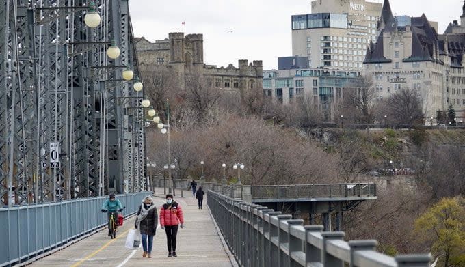 People walk along the Alexandra Bridge between Ottawa and Gatineau, Que., on Nov. 22, 2021, during the COVID-19 pandemic.