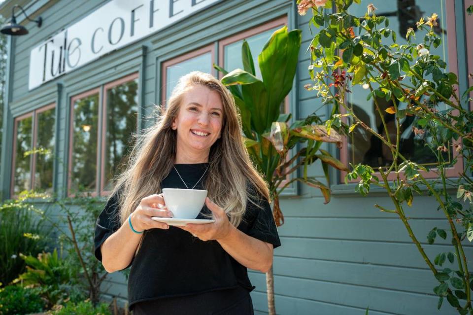 Tule Coffeehouse owner Leah Van Osten holds a cup of coffee outside her business in Elk Grove on Saturday, July 20, 2024.