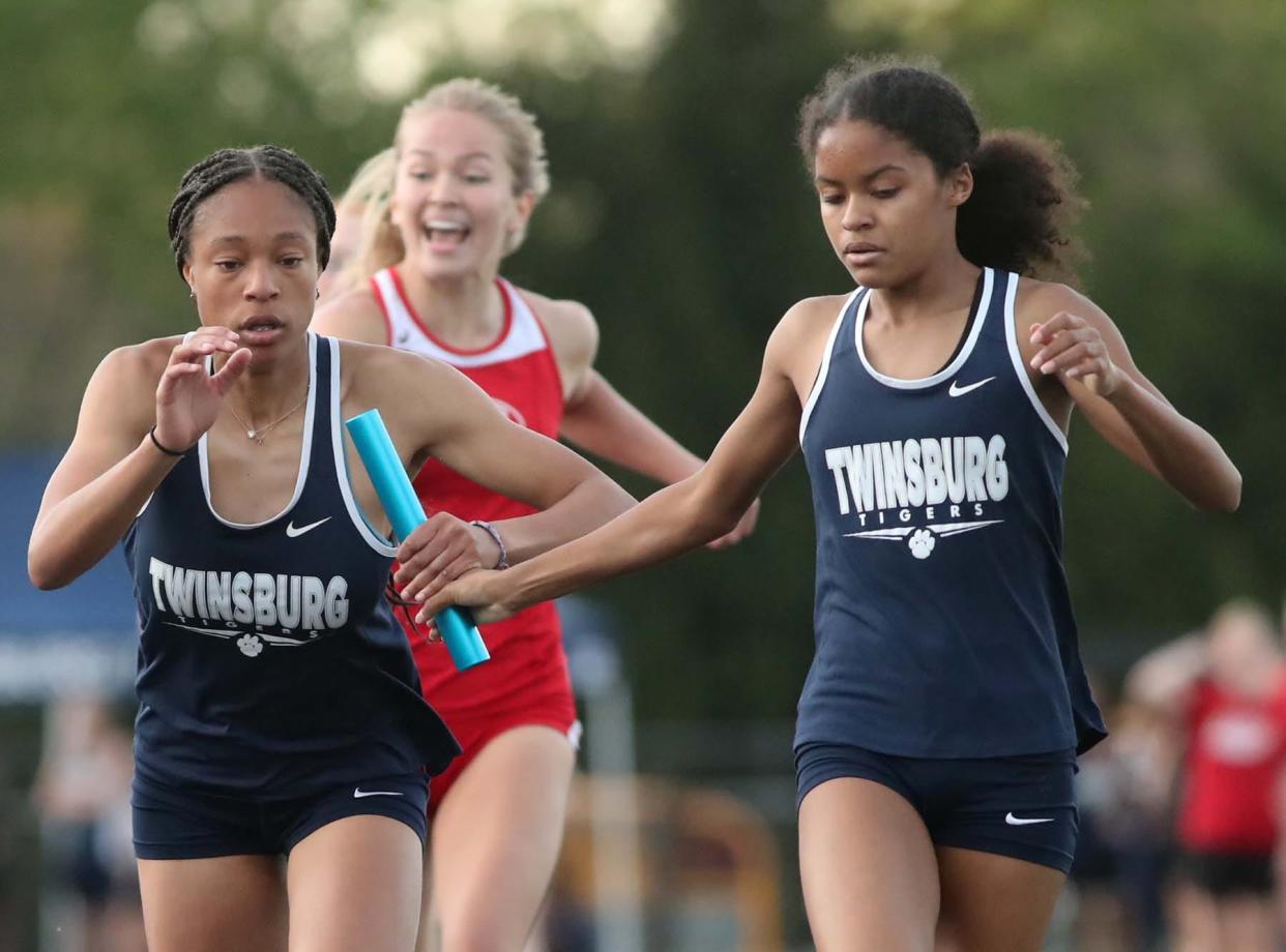 Sanayah Ruffin, right, of Twinsburg, hands off the baton to teammate Arriah Gilmer, as they and their teammates Bree Banach and anchor Sophie Besett run to a first place finish in the 4x400 meter relay with a time of 3:59.60 during the Suburban League National Conference track meet in Twinsburg on Thursday. 