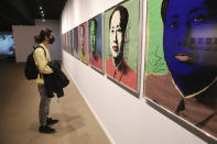 Kourosh Aminzadeh, a student of graphics, looks at China's late leader, Mao Zedong painting series by American artist Andy Warhol at Tehran Museum of Contemporary Art in Tehran, Iran on Oct. 19, 2021. Iranians are flocking to Tehran's contemporary art museum to marvel at American pop artist Andy Warhol’s iconic work. (AP Photo/Vahid Salemi)