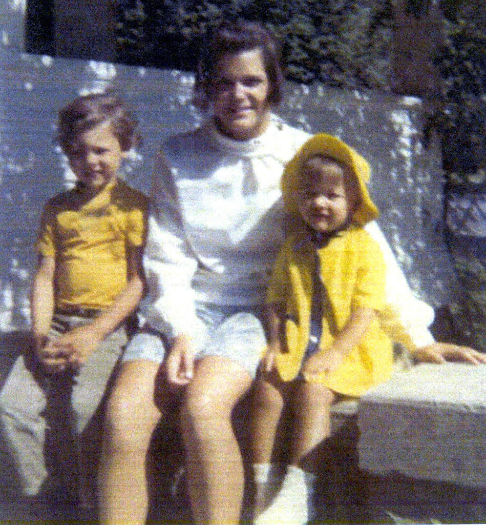 Michelle sitting with her brother and mother for a family photo