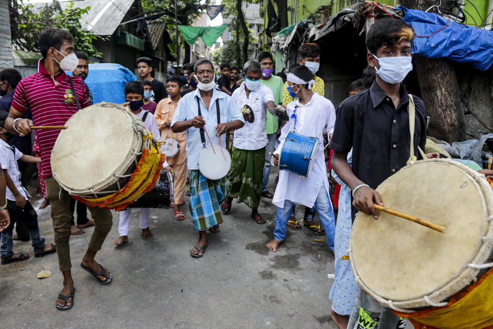 Muslims wearing face masks beat drums during a Muharram procession in Kolkata, India, Sunday, Aug. 30, 2020. India has the third-highest coronavirus caseload after the United States and Brazil, and the fourth-highest death toll in the world. (AP Photo/Bikas Das)