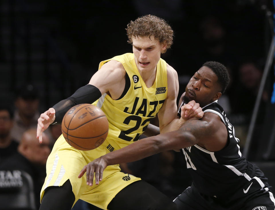 Utah Jazz forward Lauri Markkanen, left, and Brooklyn Nets forward Dorian Finney-Smith battle for the ball during the first half of an NBA basketball game Sunday, April 2, 2023, in New York. (AP Photo/John Munson)