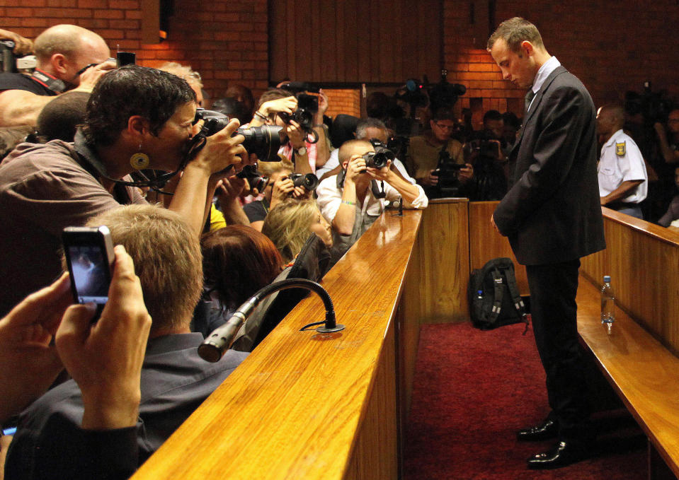 FILE - In this Wednesday, Feb. 20, 2013 file photo Olympic athlete Oscar Pistorius stands inside a court during his bail hearing at the magistrate court in Pretoria, South Africa. With his athletic triumphs tarnished by the killing of his girlfriend, Reeva Steenkamp. Pistorius, now 27, faces possibly being sent to prison until he is older than 50. Pistorius goes on trial Monday March 3, 2014. (AP Photo/Themba Hadebe, File)