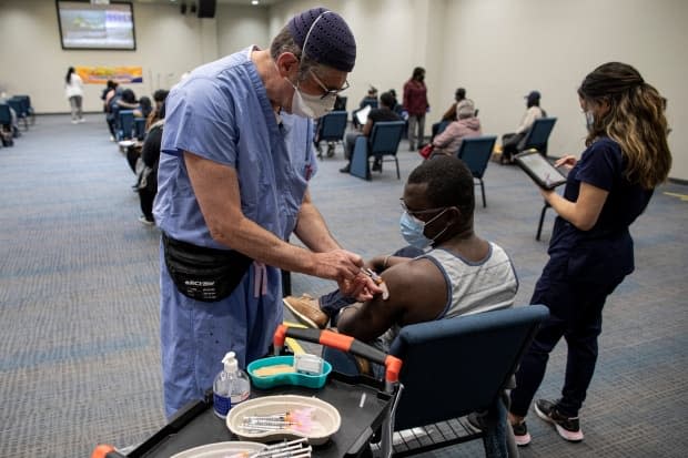 Philemon Nyarko, 36, gets a dose of the Moderna COVID-19 vaccine from Dr. Ian Katz at a temporary clinic run by Humber River Hospital at The Church Of Pentecost Canada in northwest Toronto on May 4, 2021. (Evan Mitsui - image credit)