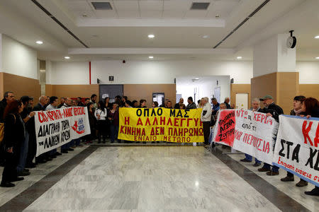 Protesters block an entrance to prevent court officials from entering the courtroom and carry out an auction in Athens, Greece, March 29, 2017. The banner in the middle reads " Solidarity is our weapon. "I Won't Pay" movement". Picture taken March 29, 2017. REUTERS/Alkis Konstantinidis