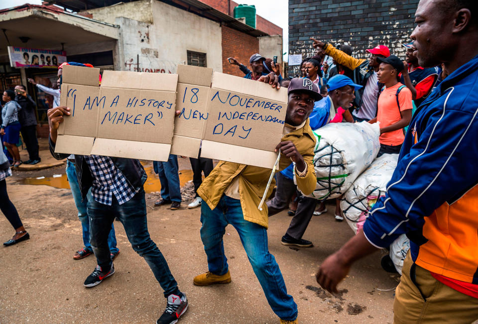 <p>People carry makeshift signs during a demonstration demanding the resignation of Zimbabwe’s president on Nov. 18, 2017 in Harare. (Photo: Jekesai Njikizana/AFP/Getty Images) </p>