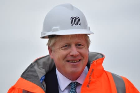 Britain's Prime Minister Boris Johnson reacts as he meets engineering graduates on the site of an under-construction tramline in Stretford
