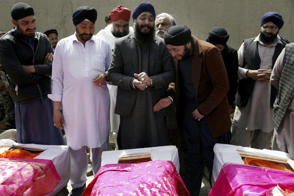 FILE - In this March 26, 2020 file photo, Afghan Sikh men mourn their loved ones during a funeral procession for those killed when a lone Islamic State gunman, rampaged through a Sikh house of worship, in Kabul, Afghanistan. The U.N. says the number of civilians killed and wounded in Afghanistan fell by 15% last year, compared to 2019. A report released Tuesday, Feb.23, 2021, attributed the drop in civilian casualties in part to an apparent tactical change by insurgents to targeted killings, fewer suicide bombings, and a stark drop in casualties attributed to international military forces. (AP Photo/Tamana Sarwary, File)