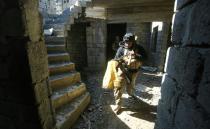 Iraqi forces take cover as they advance towards the Dindan neighborhood in western Mosul on February 25, 2017, to retake the area from Islamic State group fighters