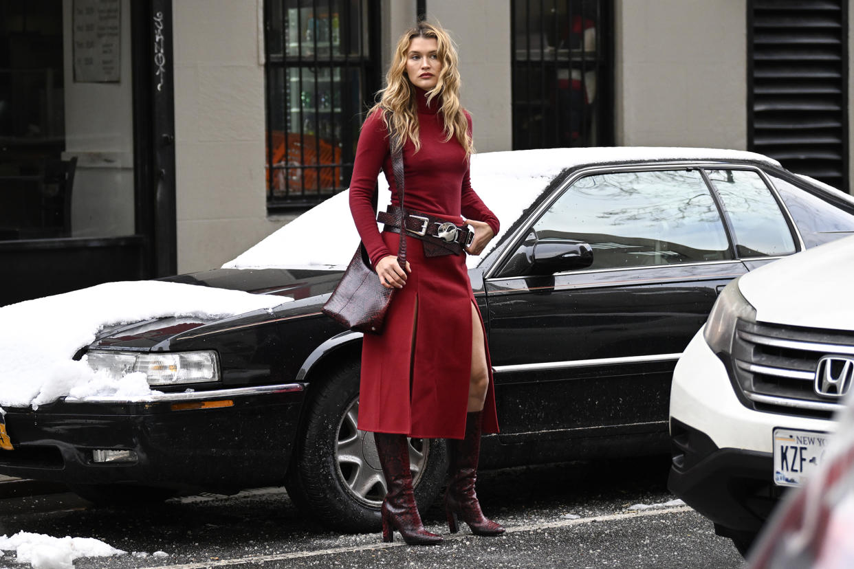 Chloe Lecareux is seen wearing a red Michael Kors dress, maroon and silver belt, maroon boots and maroon bag outside the Michael Kors show during NYFW F/W 2024 on February 13, 2024 in New York City. (Photo by Daniel Zuchnik/Getty Images)