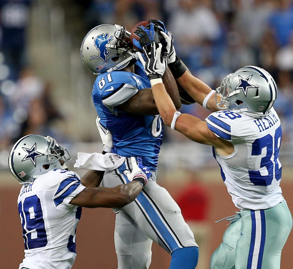 Detroit Lions receiver Calvin Johnson makes a catch against Dallas Cowboys' Brandon Carr, left, and Jeff Heath during the fourth quarter Oct. 27, 2013, at Ford Field.