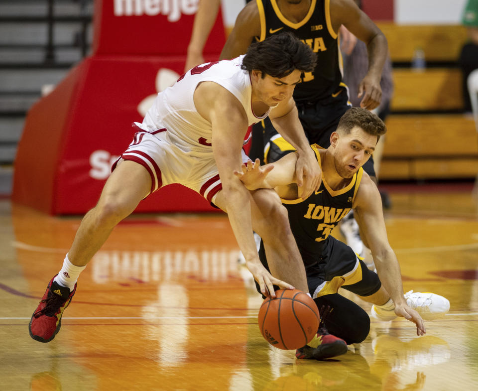 Indiana guard Trey Galloway (32), left, and Iowa guard Jordan Bohannon (3) battle for the ball during the first half of an NCAA college basketball game, Sunday, Feb. 7, 2021, in Bloomington, Ind. (AP Photo/Doug McSchooler)