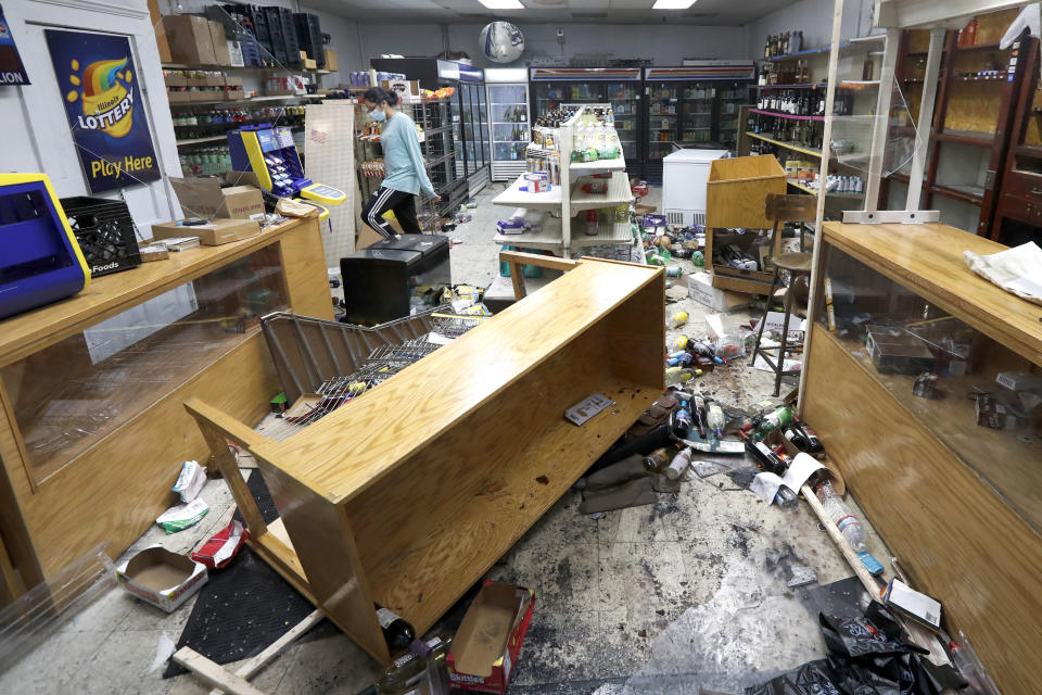 Kajal Dalal walks through her family's food and liquor store in downtown Chicago on Monday after it was vandalized.  (Photo: AP Photo/Charles Rex Arbogast)