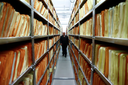 A security staff member walks between shelves containing documents of the former East German Ministry for State Security (MfS), known as the Stasi, while he poses during a tour at the central archives office in Berlin, Germany, March 12, 2019. Picture taken March 12, 2019. REUTERS/Fabrizio Bensch