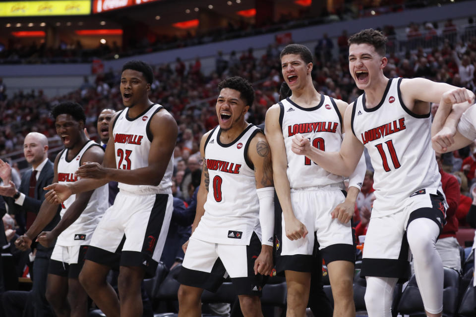 Louisville bench reacts to a dunk during the second half of an NCAA college basketball game against Syracuse Wednesday, Feb. 19, 2020, in Louisville, Ky. Louisville won 90-66. (AP Photo/Wade Payne)