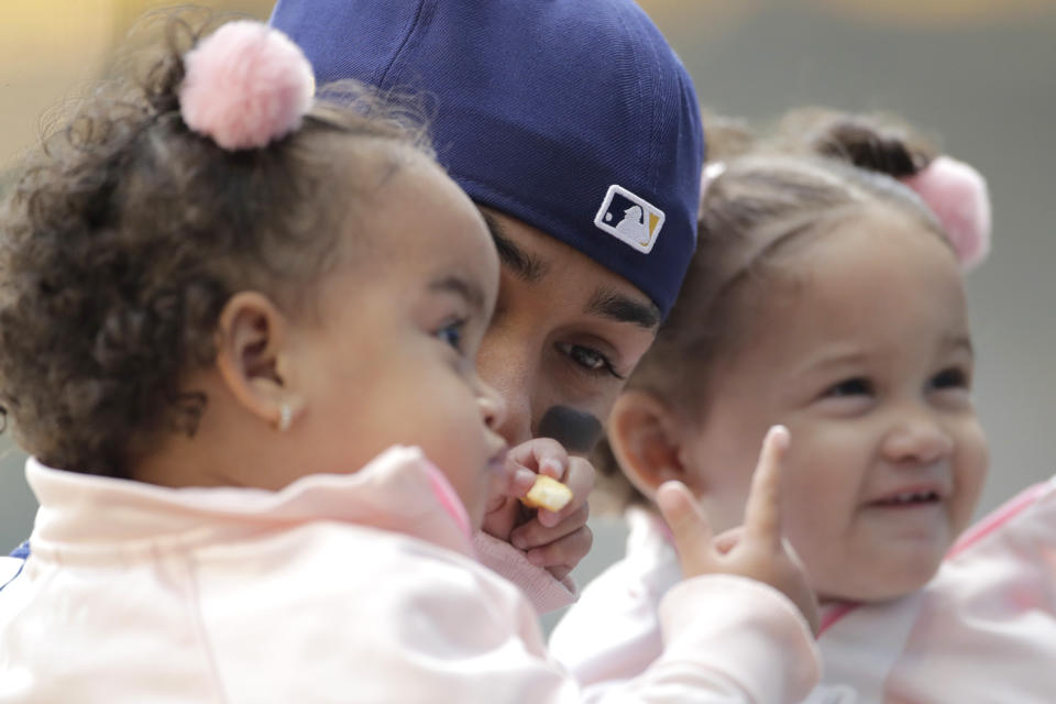 Milwaukee Brewers' Orlando Arcia holds his children before a baseball game against the Minnesota Twins Sunday, April 4, 2021, in Milwaukee. (AP Photo/Aaron Gash)