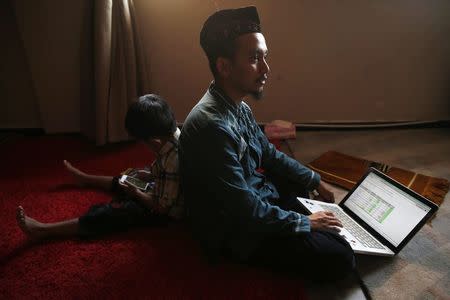 Ainun Najib, an Indonesian IT consultant based in Singapore, speaks about his work on the Indonesian elections as he waits to break fast with his son Dzuizz at a friend's house during Ramadan in Singapore July 26, 2014. REUTERS/Edgar Su