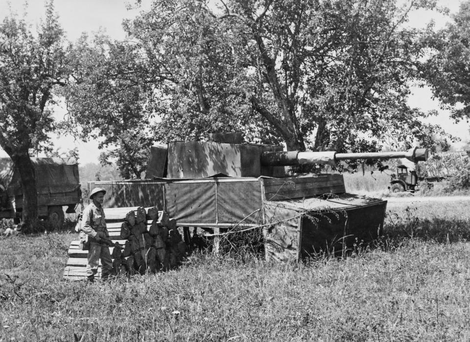 Gunner RA McLaren from the the 1st Canadian Infantry Division, 1st Canadian Corps of the British Eighth Army examines the camouflaged dummy Panzer IV tank.