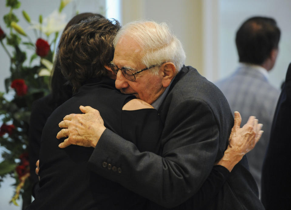 Raymond "Coach" Blanco gets a hug during visitation for his wife, former Louisiana Gov. Kathleen Blanco, at St. John's Cathedral Hall, Friday, Aug. 23, 2019, in Lafayette, La. Kathleen Blanco, who served one term as governor and various elected positions across two decades, was in Louisiana’s top job during the destruction of hurricanes Katrina and Rita in 2005. She died on Aug. 18, from cancer. (Brad Kemp/The Advocate via AP)