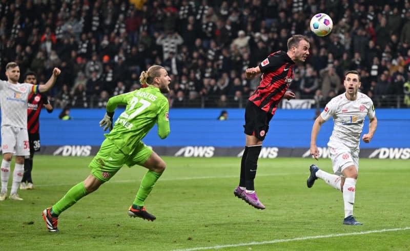 Eintracht Frankfurt's Mario Goetze (C) scores his side's first goal of the game against Mainz's Dominik Kohr (R) and goalkeeper Robin Zentner during the German Bundesliga soccer match between Eintracht Frankfurt and  1. FSV Mainz 05 at the Deutsche Bank Park. Arne Dedert/dpa