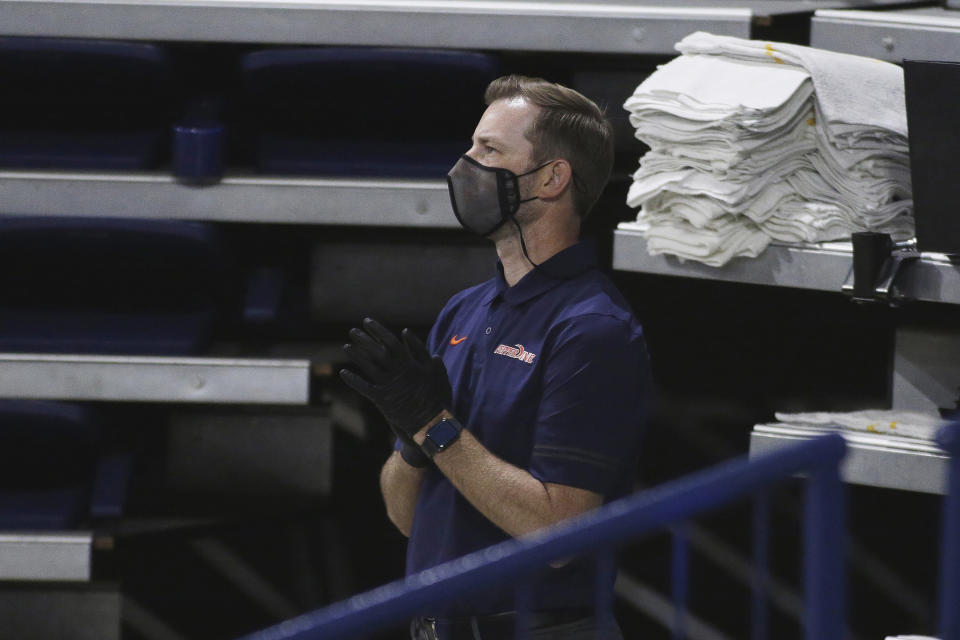 Pepperdine assistant athletic trainer Justin Ericson watches the first half of the team's NCAA college basketball game against Gonzaga in Spokane, Wash., Thursday, Jan. 14, 2021. The pandemic forced trainers to alter the way they do nearly everything. Training rooms were reconfigured with tables spread out for social distancing and limits were put on how many people are allowed in at a time. Masks became mandatory. Cleaning equipment and constant hand washing became a priority. Many schools have gone to appointment-based rehab schedules. (AP Photo/Young Kwak)