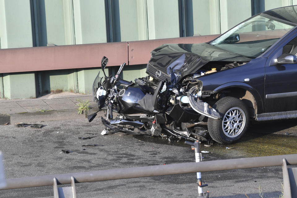 A car and a motorcycle stand on the city motorway A100 after an accident in Berlin, Germany, Wednesday, Aug. 19, 2020. The city's highway was still shut down after a series of traffic accidents that were allegedly all caused by one man. (Paul Zinken/dpa via AP)