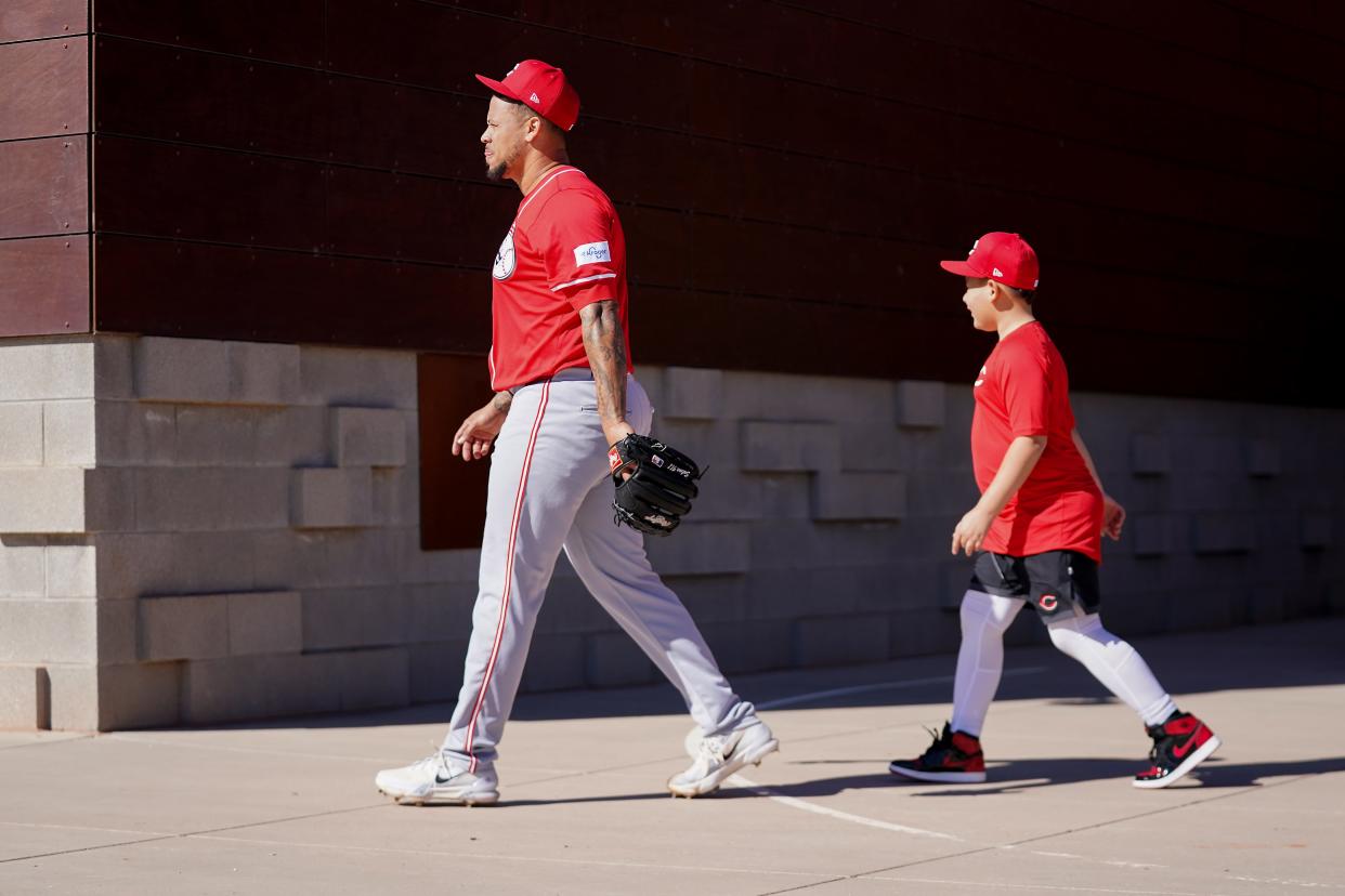 Cincinnati Reds pitcher Frankie Montas walks with this son, Michael, inside the facility during spring training workouts, Monday, Feb. 19, 2024, at the team's spring training facility in Goodyear, Ariz.