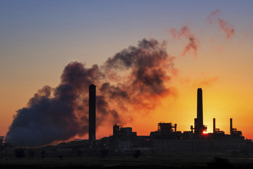 A coal-fired power plant is silhouetted against the morning sun in Glenrock, Wyo., in July. (Photo: J. David Ake/AP)