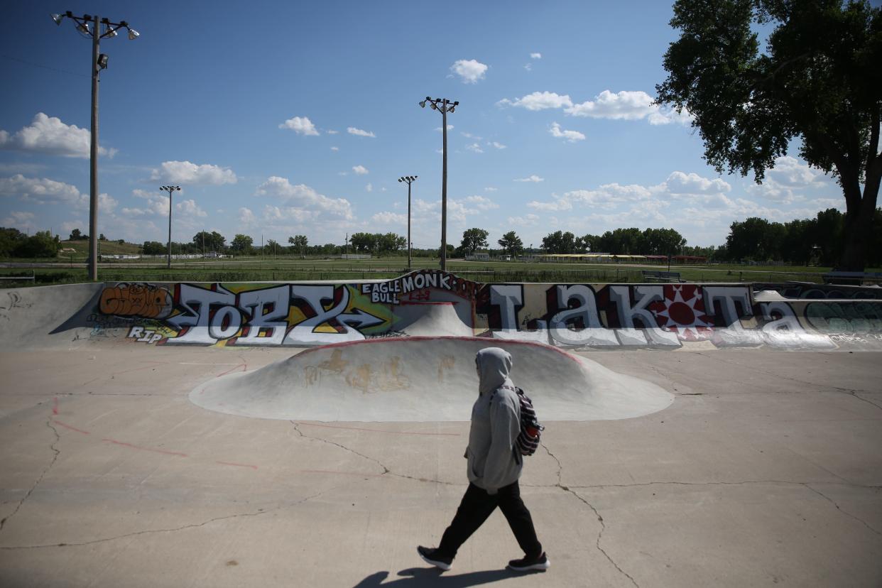 A student walks home from the Pine Ridge High School through the skate park in Pine Ridge on Monday, Aug. 28, 2023.
